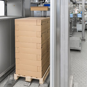 Sobald sich die Palette im Magazin befindet, erfasst ein Scanner die Anordnung der Umkartons auf der Palette. Der Greifarm transportiert den Umkarton zur Auspackstation.