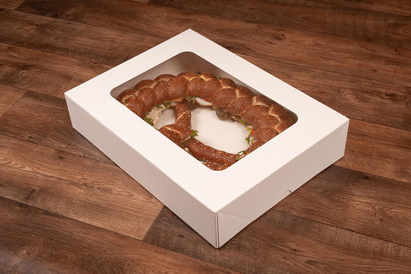 Sicher verpackt und gut sichtbar: Durch das Klarsichtfenster setzt die Cateringbox Frischeprodukte wie belegte Brezeln appetitlich in Szene.